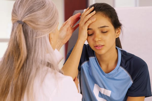 girl holding head suffering from a concussion